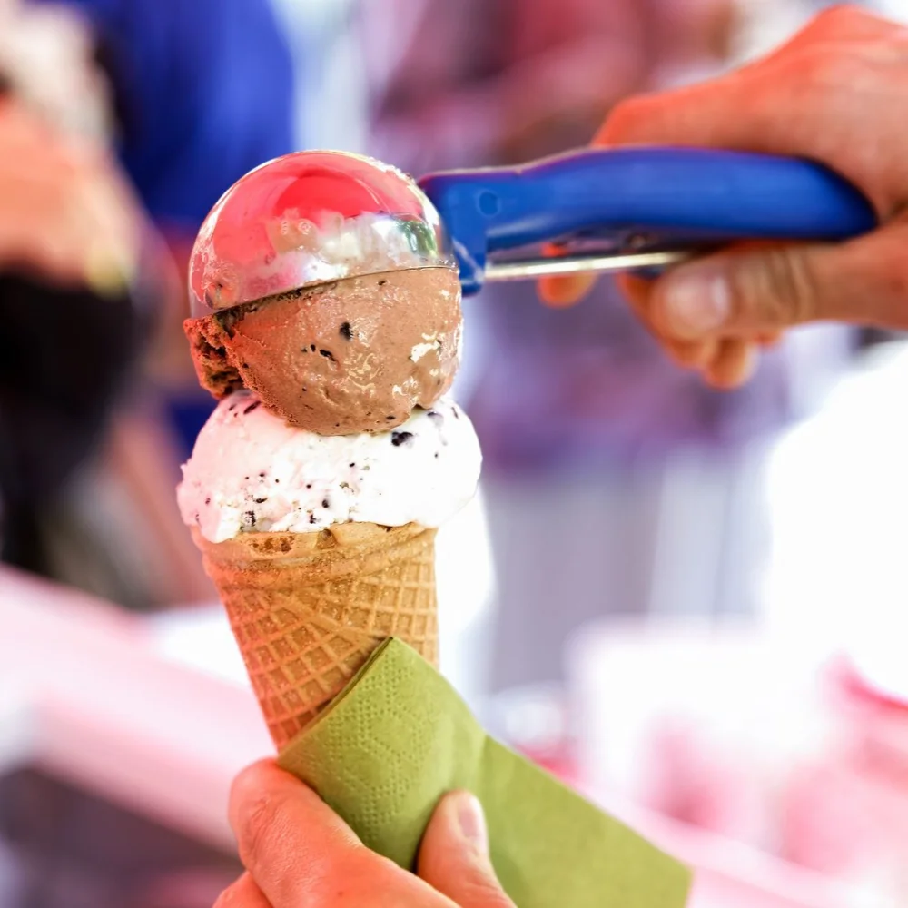 A generous scoop of ice cream added to a waffle cone